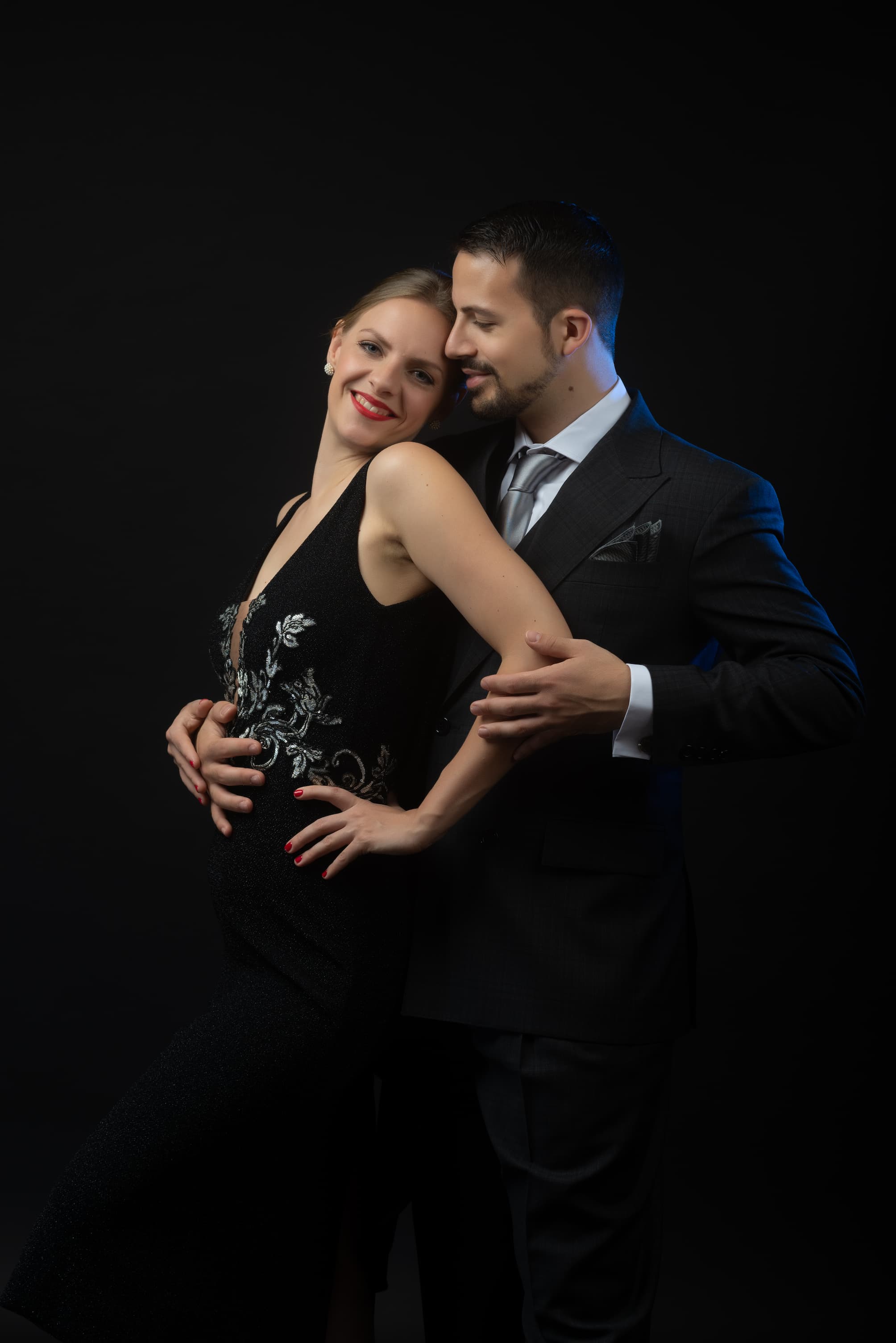 Juliana und Fadi stehen freudig und innig hintereinander, elegant gekleidet